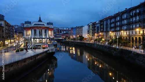 Northern spanish town's cityscape illuminated by city lights by evening