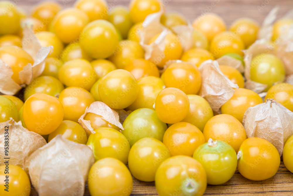 Physalis fruit on wooden background, closeup shot, local focus Physalis fruit on wooden background, closeup shot, local focus