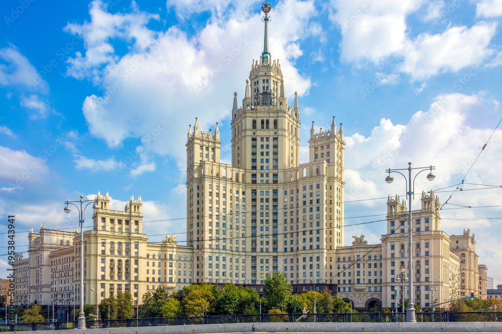 Fototapeta premium The iconic high-rise building on Kotelnicheskaya Embankment in Moscow, showcasing its classic Stalinist architecture against a bright, cloudy sky.