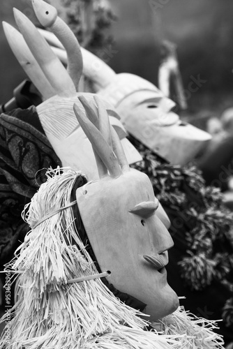 carved wooden mask of The Carnival at Lazarim, Portugal in the year 2023. The picture shows some costumed people. black and white
