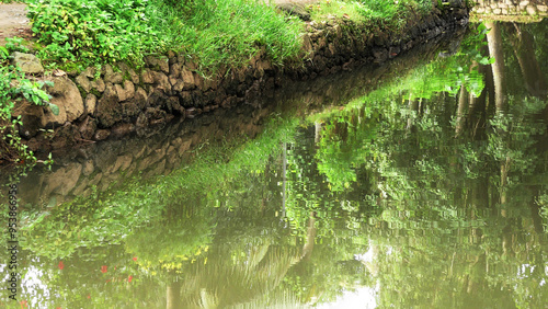 A gravel pile on the banks of a calm flowing river