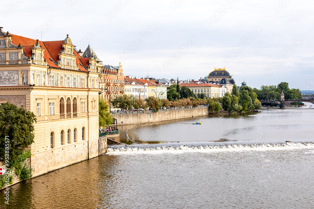 Scenic view of the Vltava River and historic architecture in Prague during a calm afternoon Scenic view of the Vltava River and historic architecture in Prague during a calm afternoon