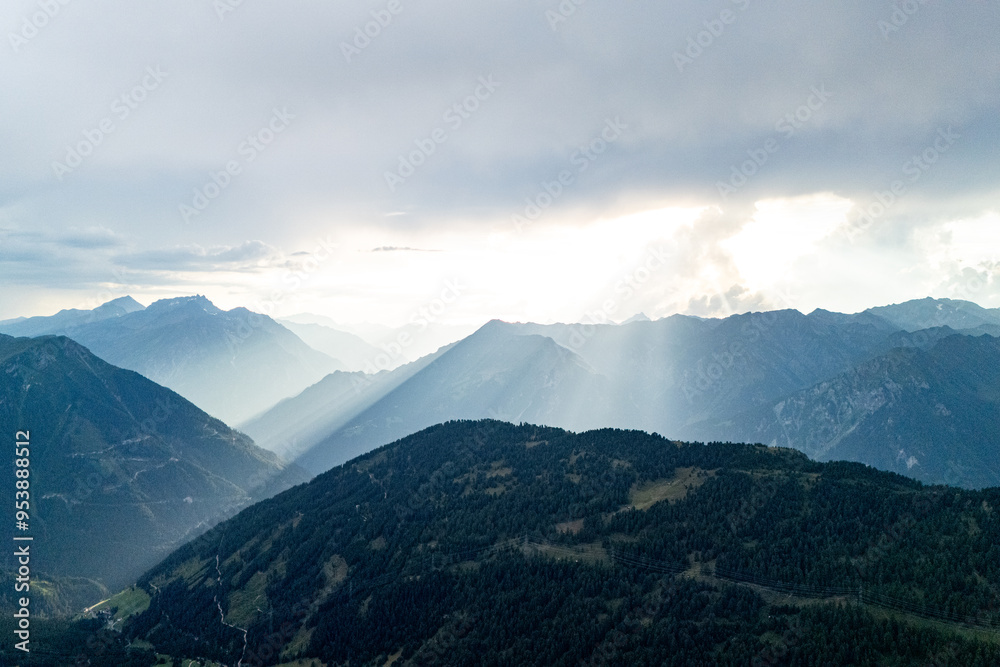 Dramatic mountain landscape in the late afternoon with sweeping views and sunlight breaking through cloud cover in the distance