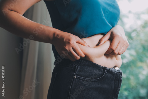 fat woman, fat belly, chubby, obese woman hand holding excessive belly fat with measure tape, woman diet lifestyle concept