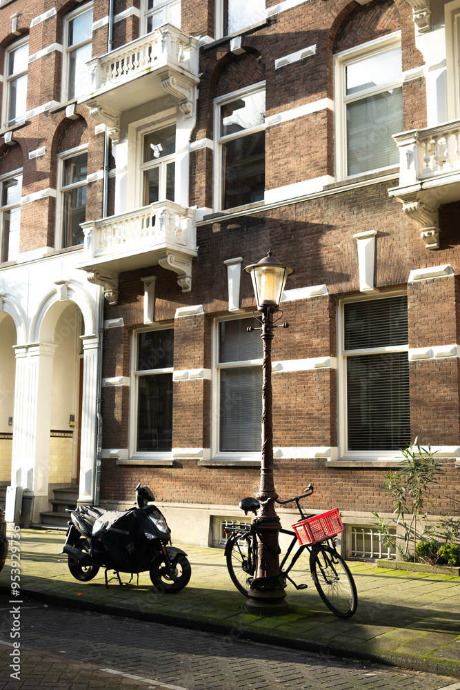 Bicycle and moped sat outside of a beautiful building in central Amsterdam Bicycle and moped sat outside of a beautiful building in central Amsterdam