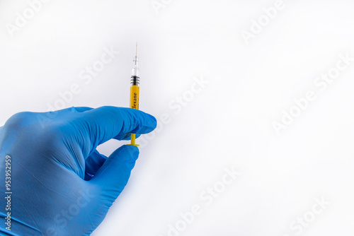 A syringe with the anticoagulant drug Clexane in the hand of a doctor wearing a blue rubber glove photo