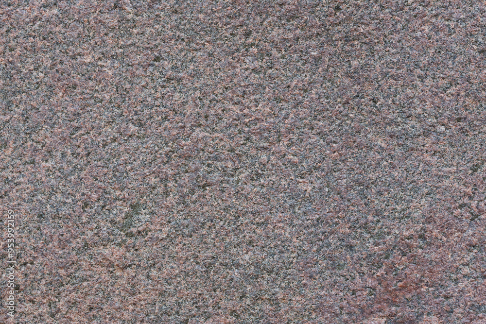 Granite texture. Natural pink granite with a grainy pattern. Stone background. Solid rough surface of rock. Durable construction and decoration material. Close-up.