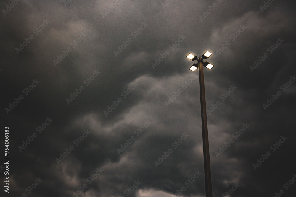 Illuminated lamp post under a brewing, ominous storm. Illuminated lamp post under a brewing, ominous storm.