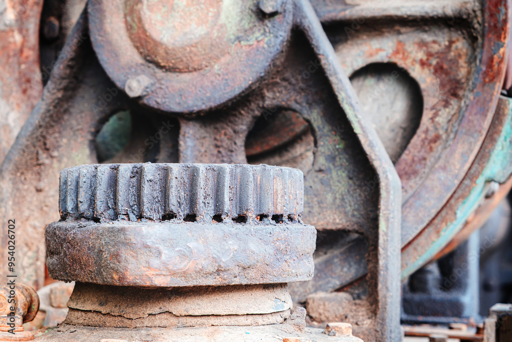 A rusty old machine with a worn out gear. The image has a mood of decay and neglect