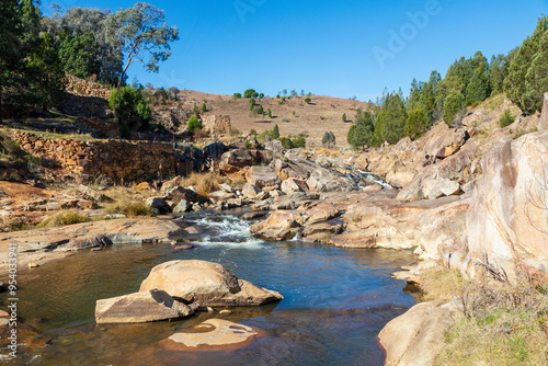 Photograph of water flowing in Adelong creek near the Adelong Falls Gold Mine ruins in the Snowy Mountains in New South Wales in Australia.