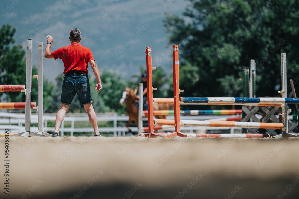 Horse riding instructor wearing red shirt guiding equestrian training session with horse and rider in outdoor setting