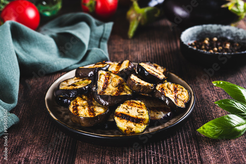 Obraz na płótnie Appetizing spicy grilled eggplant pieces on a plate on the table w salonie