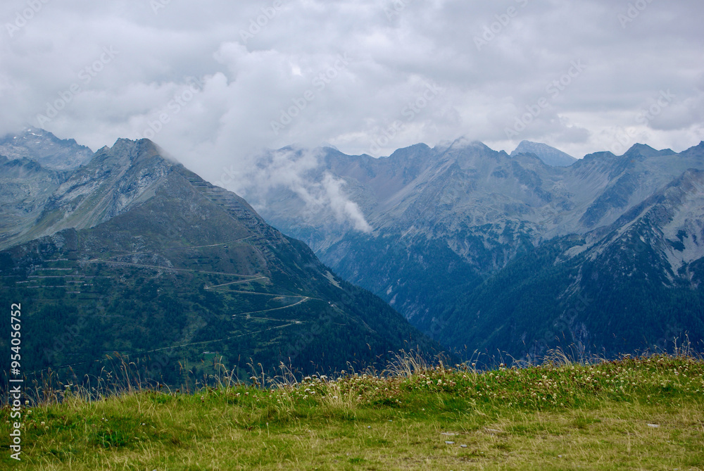 Fototapeta premium View of an amazing mountain landscape on a hazy day with gray clouds and fog over the peaks in autumn in Austria.