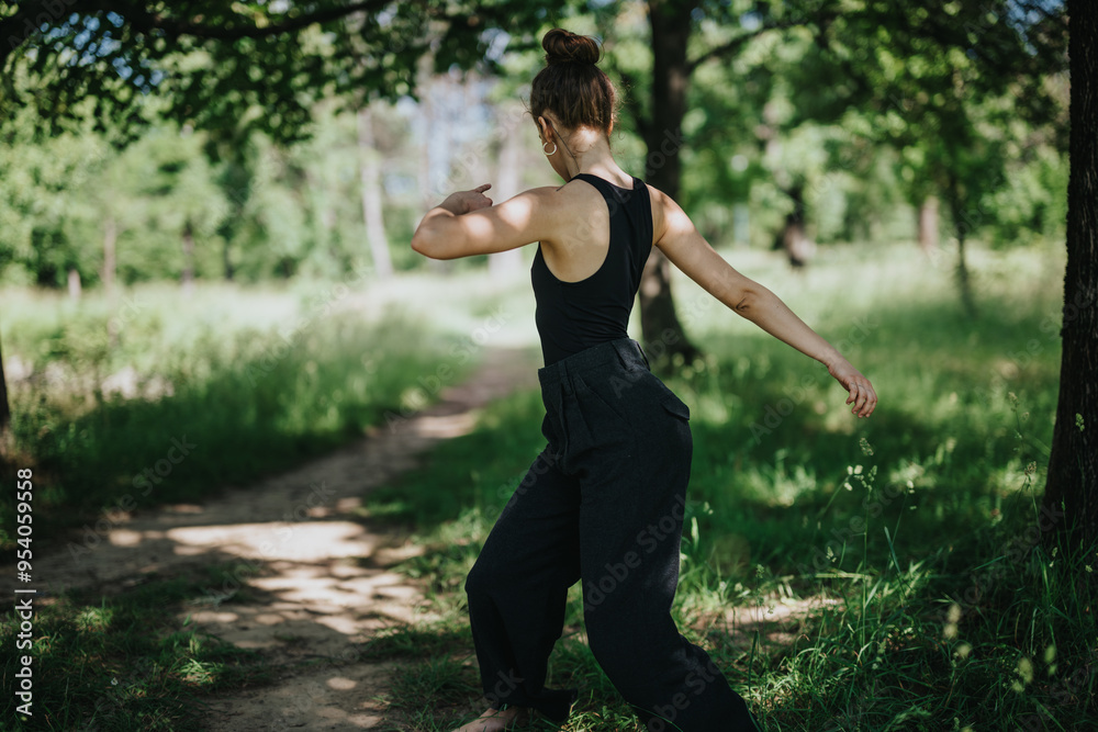 Young girl engaged in expressive modern dance amid nature, surrounded by lush greenery and forest ambiance. Young girl engaged in expressive modern dance amid nature, surrounded by lush greenery and forest ambiance.