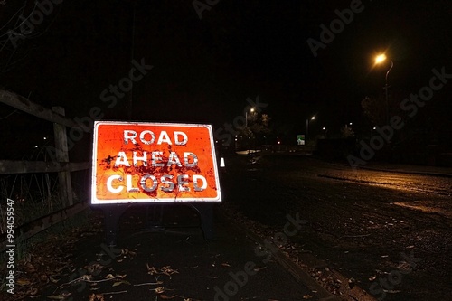 'ROAD AHEAD CLOSED' sign lit up at night