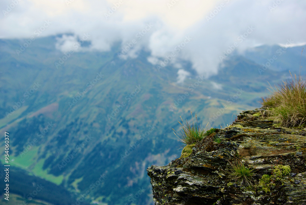 View of an amazing mountain landscape on a hazy day with gray clouds and fog over the peaks in autumn in Austria. View of an amazing mountain landscape on a hazy day with gray clouds and fog over the peaks in autumn in Austria.