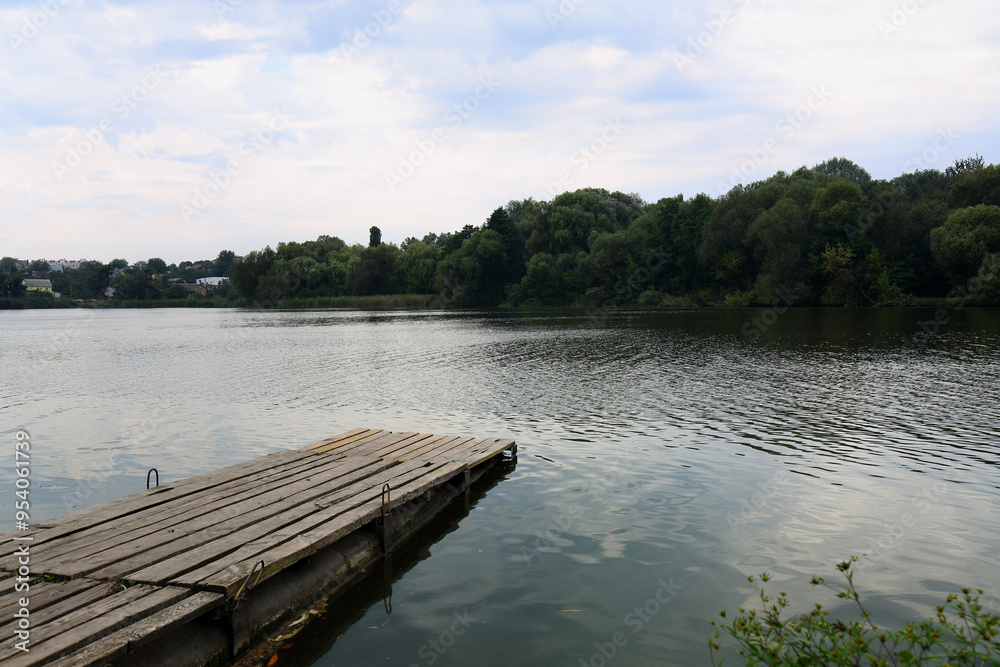 A wooden pier on the river in a gloomy day