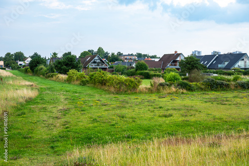 Green meadows and houses in the background at the brondby strandpark, Denmark photo