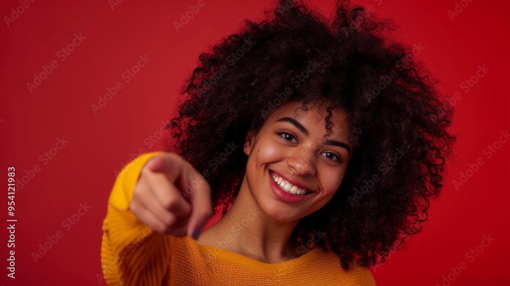 A joyful woman with curly hair points at the viewer against a vibrant red background. Her expression is warm and inviting. Great for marketing and social media. AI A joyful woman with curly hair points at the viewer against a vibrant red background. Her expression is warm and inviting. Great for marketing and social media. AI