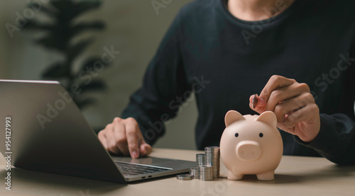 Obraz na płótnie person placing a coin into a piggy bank, symbolizing saving money, financial planning, online banking and economic. stack coins the piggy bank of accumulating wealth, managing expenses and investment. w salonie