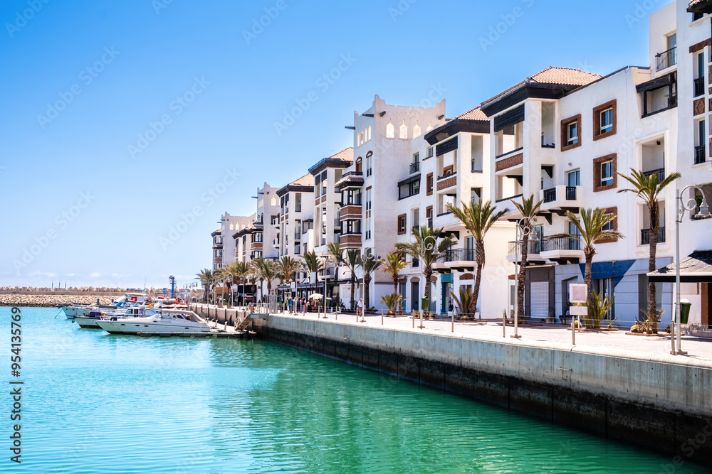 Obraz premium Agadir Marina with luxury apartments, boats in harbor, shops and restaurants. Popular tourist destination in Moroccan seaside resort on shore of Atlantic ocean in Africa