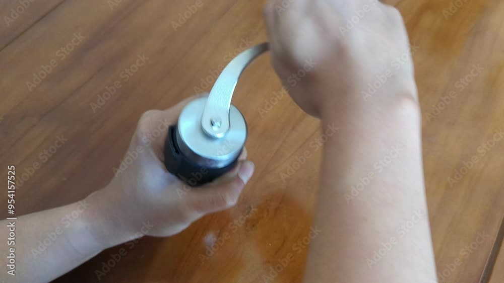 Close up a hands grinds coffee beans in a manual coffee grinder, To make a coffee menu in the home, prepare to make caffeine drinks, 4K. Close up a hands grinds coffee beans in a manual coffee grinder, To make a coffee menu in the home, prepare to make caffeine drinks, 4K.