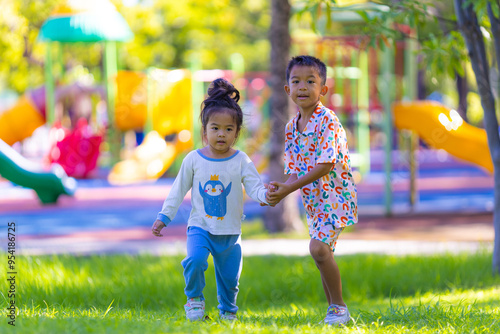 Adorable kids boy and girl enjoying run on green grass playgound outdoor activity photo