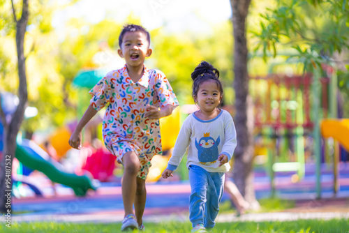 Adorable kids boy and girl enjoying run on green grass playgound outdoor activity photo