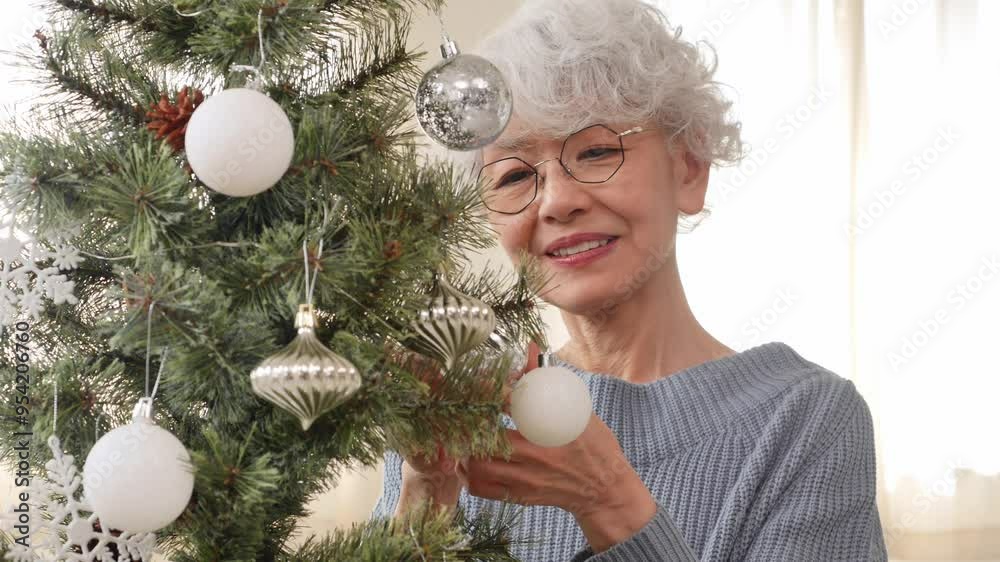 クリスマスツリーのオーナメントを飾るシニア女性 クリスマスツリーのオーナメントを飾るシニア女性