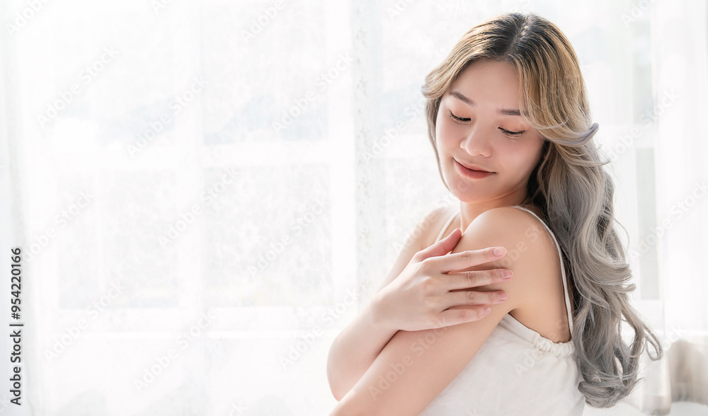Portrait of beauty smiling asian woman applying a lotion to arm hand touch skin during dressing up. Cute asian model girl. Skincare body lotion, beauty clinic skincare spa, woman lifestyle concept Portrait of beauty smiling asian woman applying a lotion to arm hand touch skin during dressing up. Cute asian model girl. Skincare body lotion, beauty clinic skincare spa, woman lifestyle concept