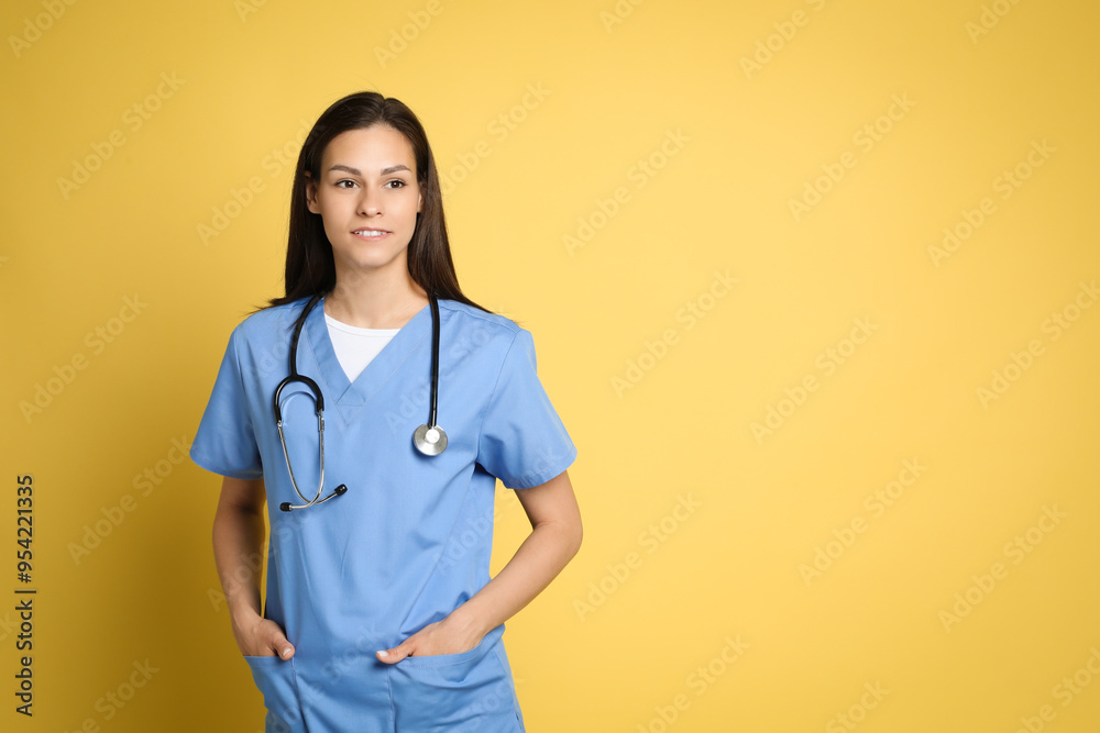 Portrait of smiling nurse with stethoscope on yellow background. Space for text Portrait of smiling nurse with stethoscope on yellow background. Space for text