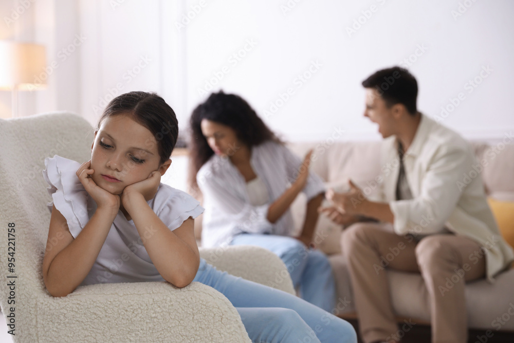 Divorce concept. Angry couple arguing at home, focus on their sad daughter Divorce concept. Angry couple arguing at home, focus on their sad daughter