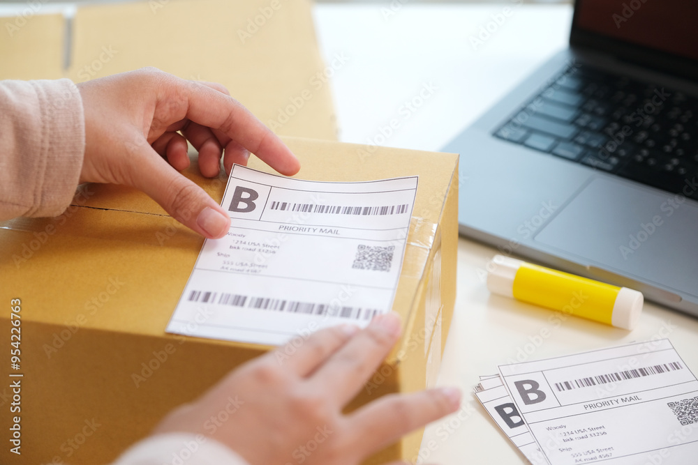 Close up of woman hand holding product box with bar code for delivering to customer, online shopping, small business Close up of woman hand holding product box with bar code for delivering to customer, online shopping, small business