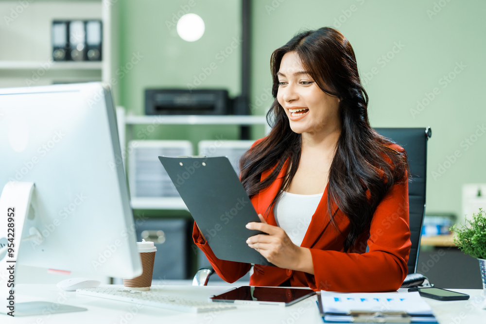 young Asian businesswoman in a formal suit works at her desk in a modern glass office, consulting on LGBTQ-inclusive strategies across various business domains, including HR, IT, and marketing. young Asian businesswoman in a formal suit works at her desk in a modern glass office, consulting on LGBTQ-inclusive strategies across various business domains, including HR, IT, and marketing.