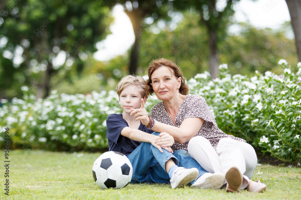 Grandchild and grandmother relaxing at park or grass field. Grandchild and grandmother relaxing at park or grass field.