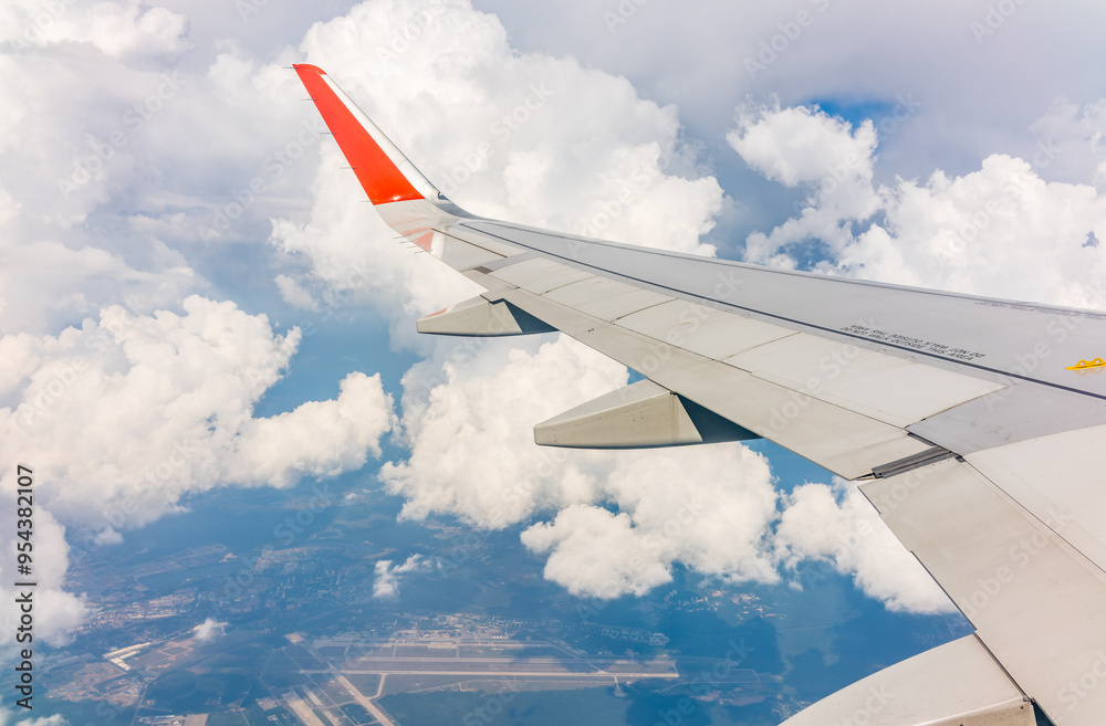View from the airplane window at a beautiful cloudy sky and the airplane wing View from the airplane window at a beautiful cloudy sky and the airplane wing