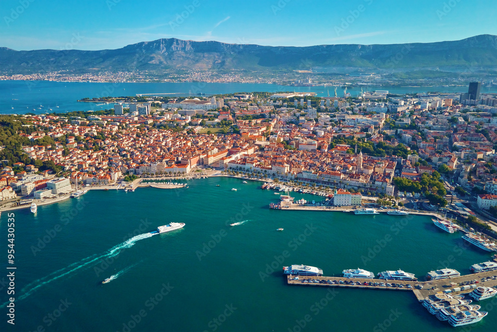 Aerial view of Split, Croatia. Cityscape of coastal touristic city with harbor with mountains in background. Old town with historical red roof tiled buildings near Adriatic Sea