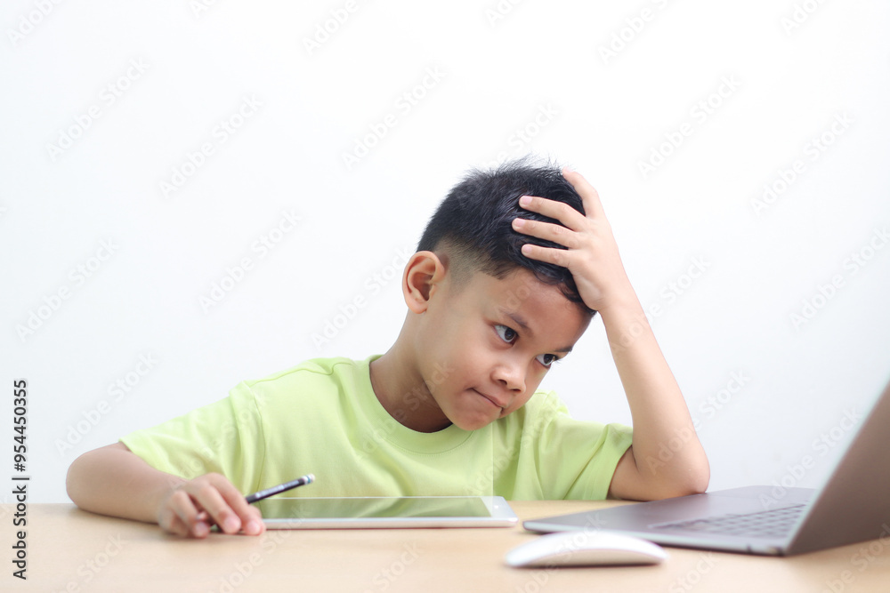A little asian boy studying online learning class with online video call zoom teacher at home. E-learning or Home schooling education concept. A little asian boy studying online learning class with online video call zoom teacher at home. E-learning or Home schooling education concept.