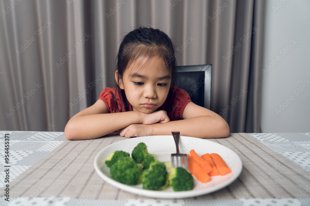 Little cute kid girl refusing to eat healthy vegetables. Children do not like to eat vegetables. Little cute kid girl refusing to eat healthy vegetables. Children do not like to eat vegetables.