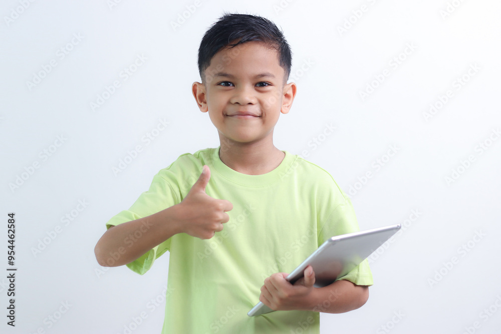 smiling little boy stiiting and holding a tablet. smiling little boy stiiting and holding a tablet.