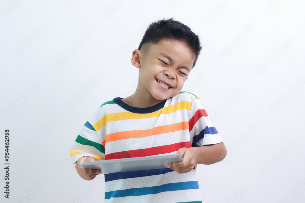 smiling little boy stiiting and holding a tablet. smiling little boy stiiting and holding a tablet.