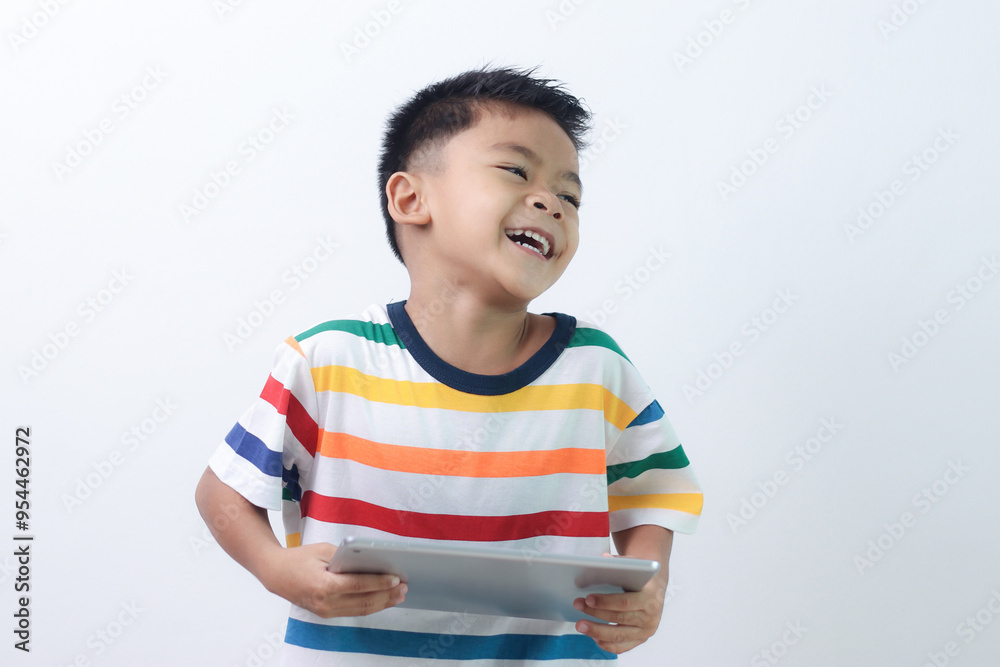 smiling little boy stiiting and holding a tablet. smiling little boy stiiting and holding a tablet.