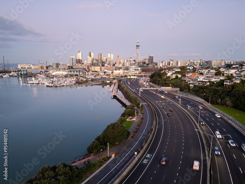 Obraz na płótnie Auckland, New Zealand: Dramatic aerial view of the Westhaven highway leading to Auckland downtown district skyline at sunset in New Zealand. w salonie