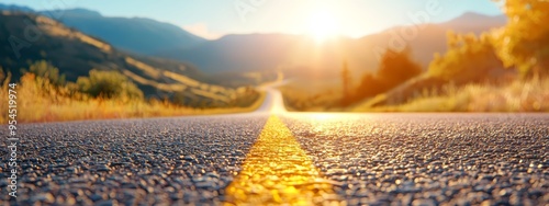  A crisp image of a mountain road, sun illuminating tree canopies