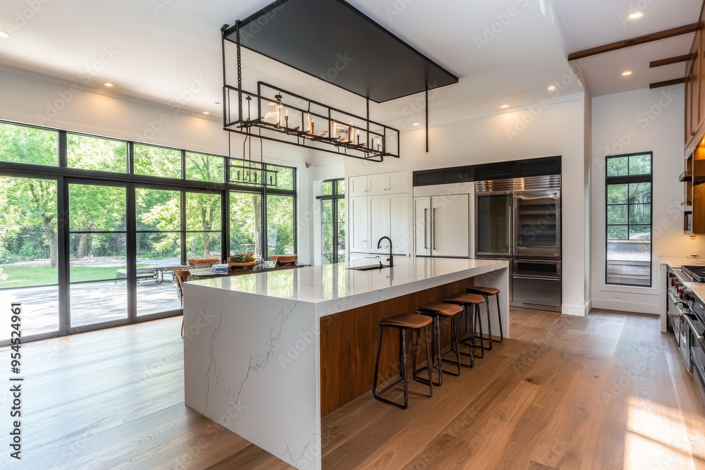 Modern kitchen with marble island, stainless steel appliances, bar stools, pendant lights, and wooden flooring, creating an elegant atmosphere.