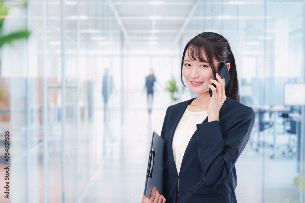 オフィスの廊下を歩く若い女性 オフィスの廊下を歩く若い女性