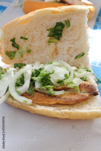 Canvas Print Fish sandwhich with grilled mackarel, raw onion in white wheat bread roll