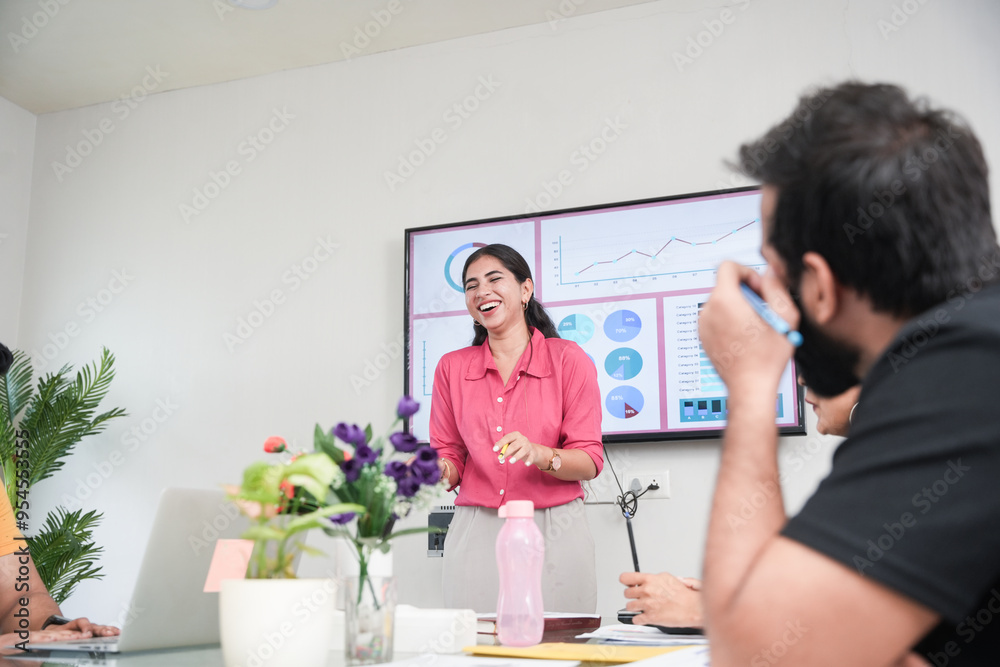 Young indian woman at office discussing about business project to team members or colleagues in meeting. Start up, leadership and workplace concept. Young indian woman at office discussing about business project to team members or colleagues in meeting. Start up, leadership and workplace concept.