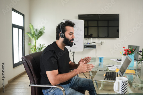 young indian man call center agent  wearing headset talking to client, telemarketing operator have conversation,  customer tech assistance support office. online classes. conference call