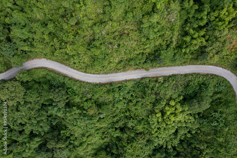 Aerial view on mountain road from drone of road in the middle of the forest in rainy day in spring, green foliage in empty asphalt road through the mountains. Aerial view on mountain road from drone of road in the middle of the forest in rainy day in spring, green foliage in empty asphalt road through the mountains.